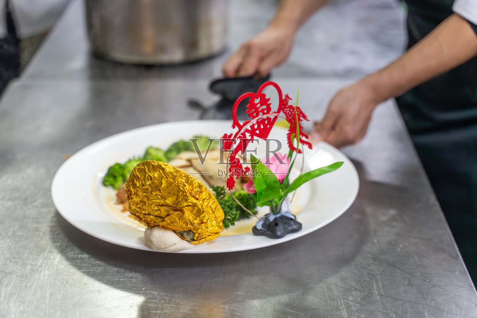 厨师的手正在用鲍鱼片做菜照片摄影图片