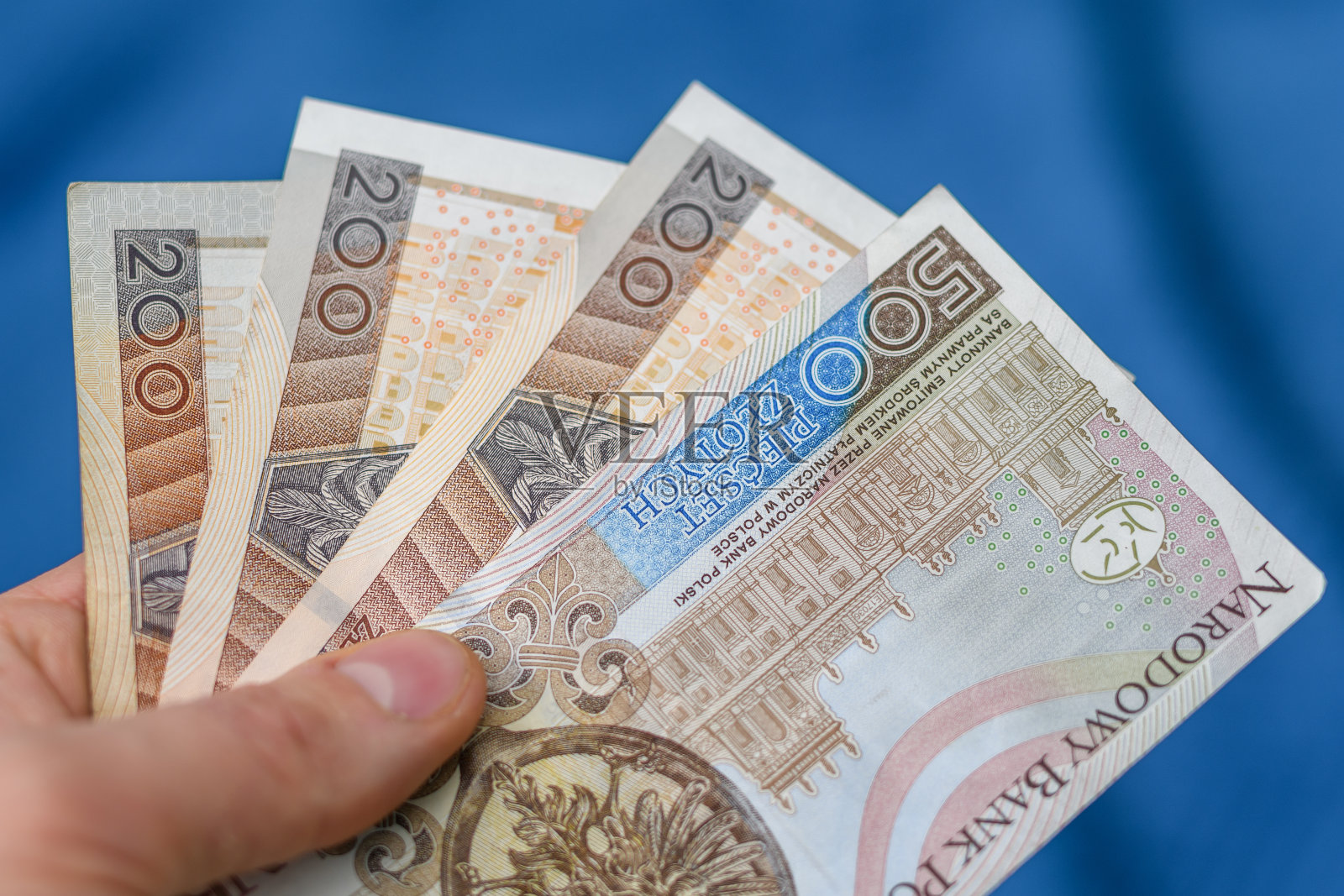 波兰200兹罗提和500兹罗提纸币，蓝色背景模糊不清照片摄影图片