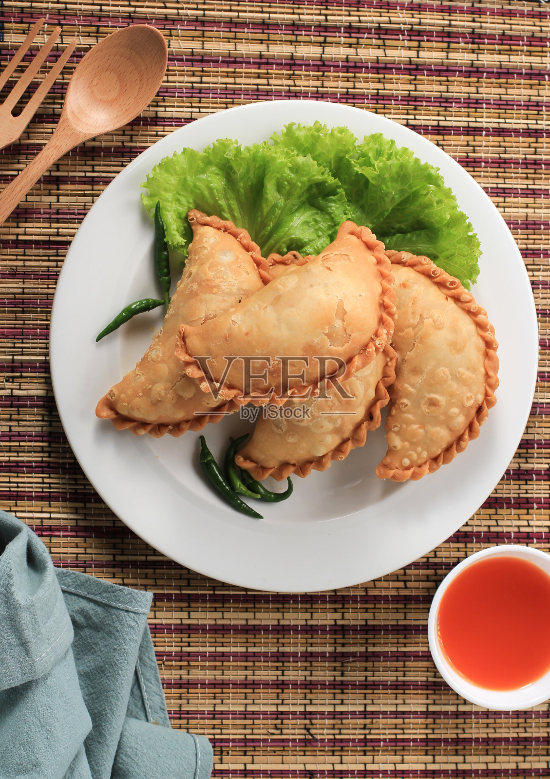 印尼粉饼，白色盘子，配茶。咖喱泡芙(Karipap)或Jalangkote Makasar很受欢迎照片摄影图片