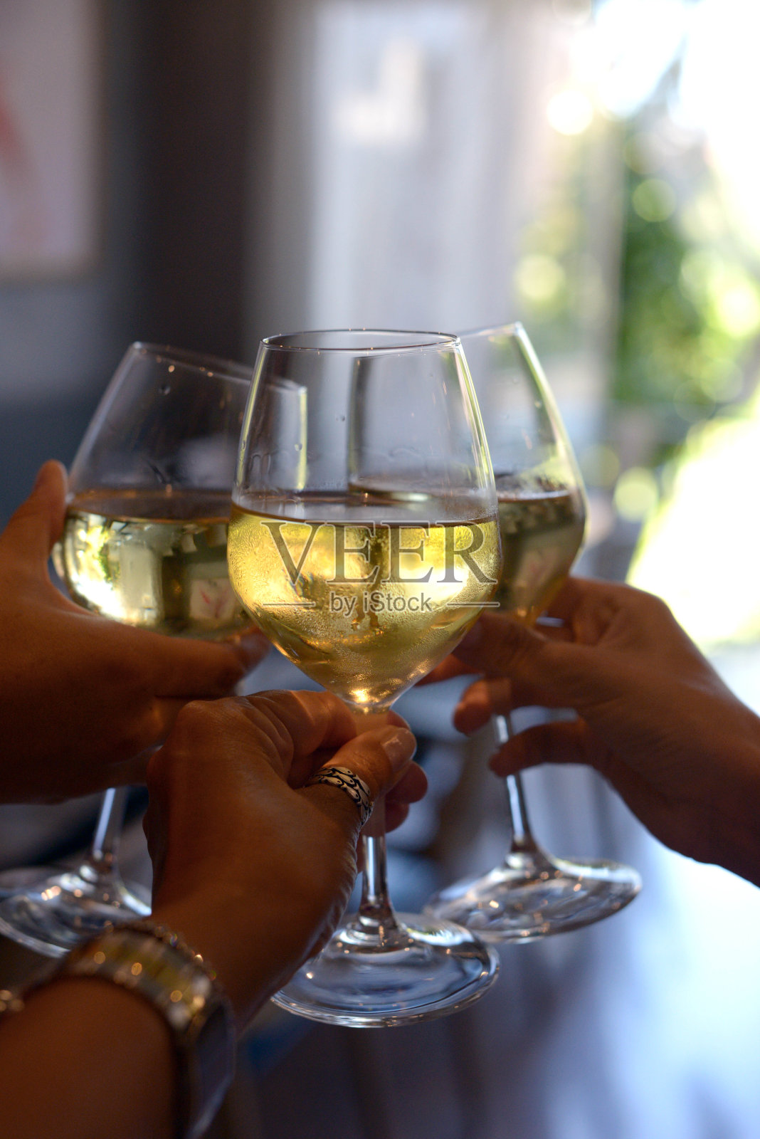 手捧白葡萄酒，与朋友见面，在餐厅餐桌上敬酒，周末，香槟，庆典，背景，选择性焦点照片摄影图片