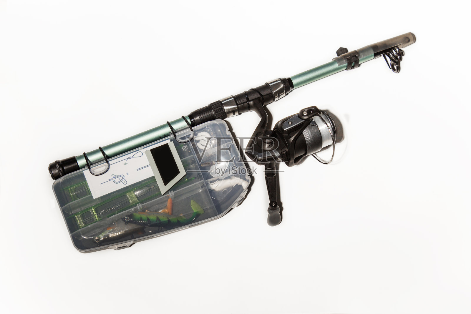 新的鱼竿和卷轴在一个白色的背景与渔夫的钓具箱与诱饵和渔具隔离。钓鱼配件。钓鱼旋转照片摄影图片