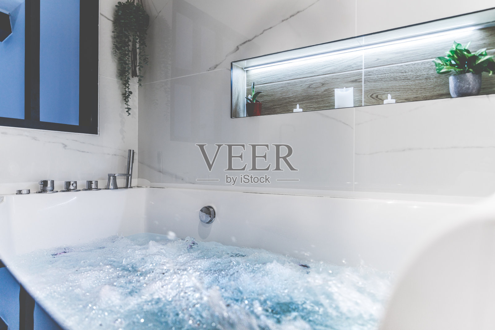 在舒适阁楼的豪华现代浴室里，泡泡水疗按摩浴缸的特写照片摄影图片