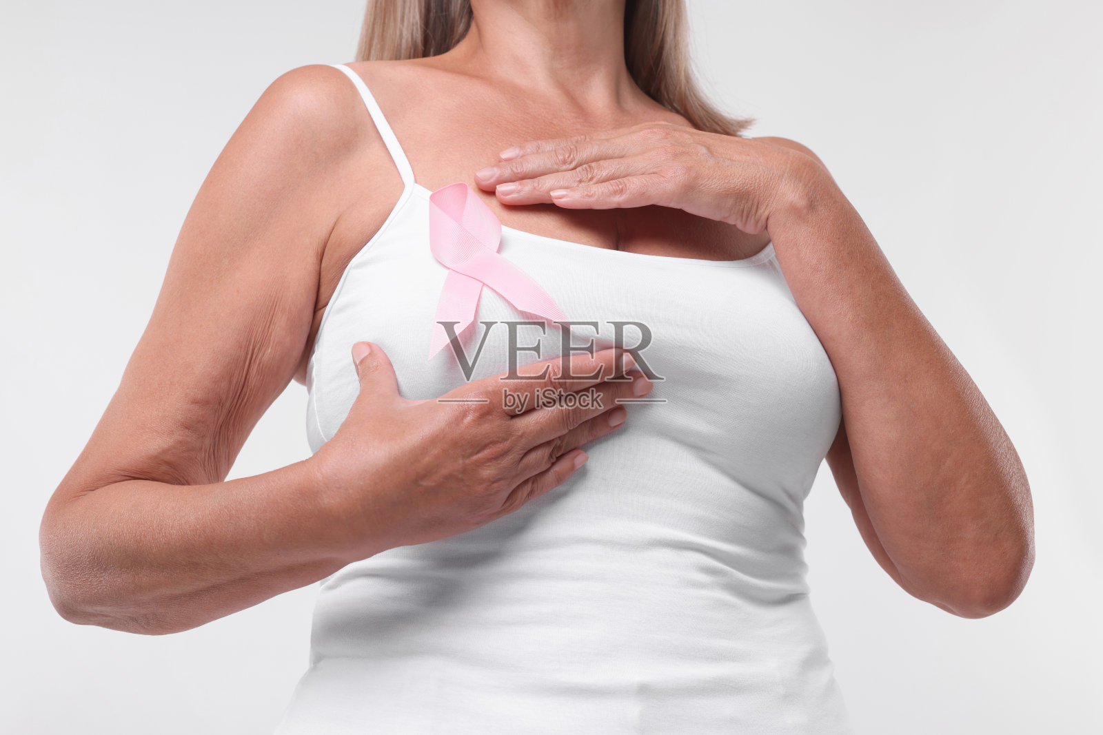 白底粉色丝带的女人，特写。乳腺癌意识照片摄影图片