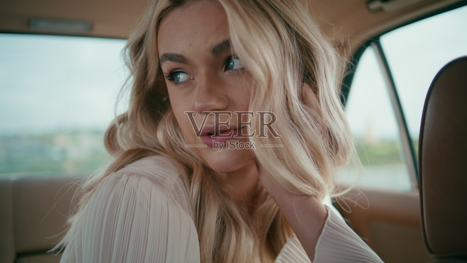 肖像美女乘客坐在复古车后座看着相机。照片摄影图片