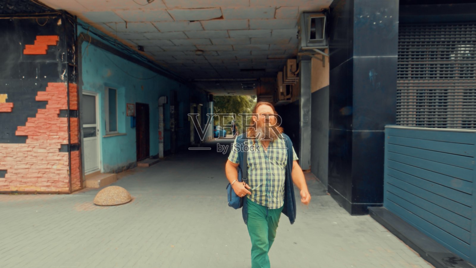 一个红胡子男人匆匆忙忙地穿过城市照片摄影图片