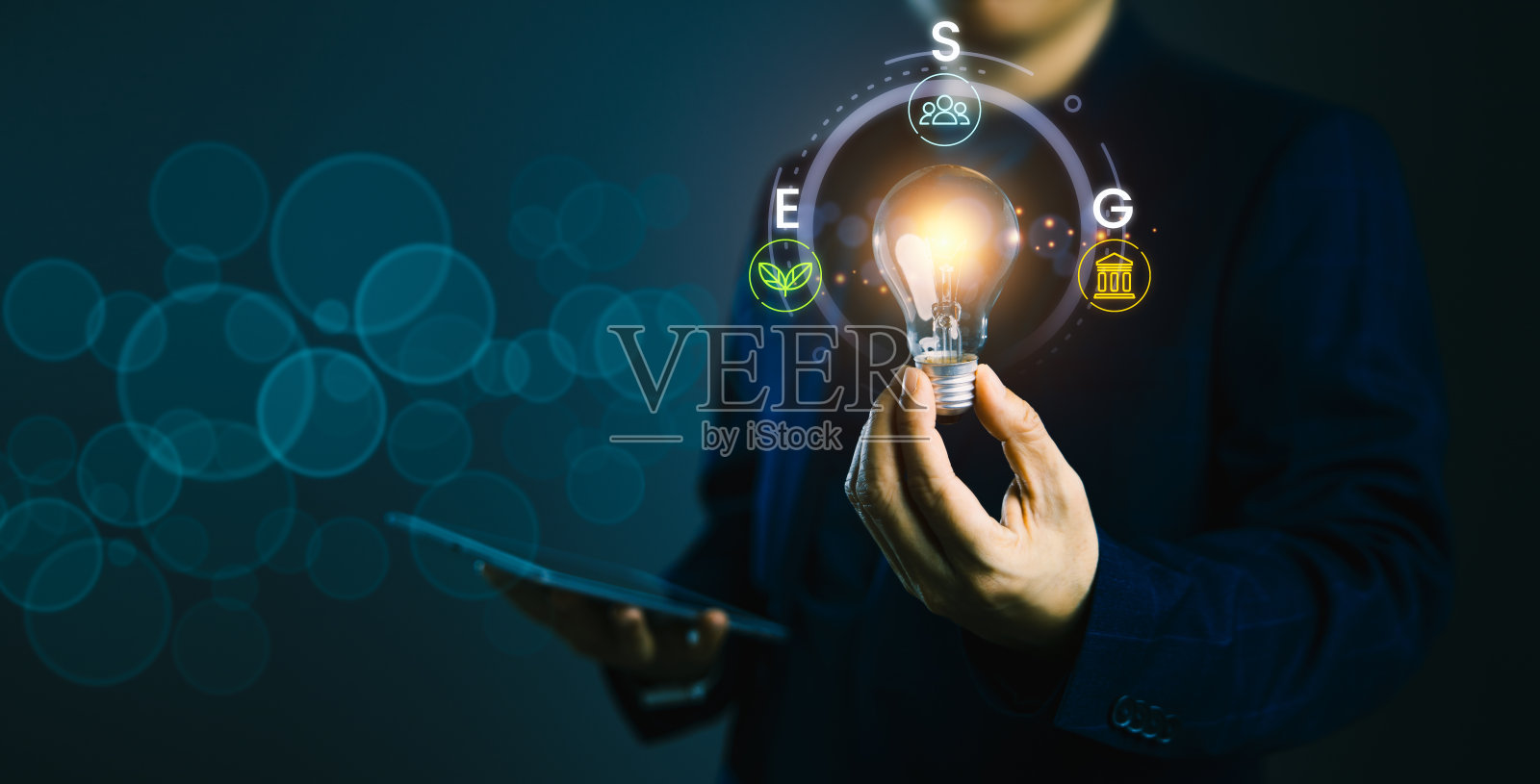 照亮ESG领导:拿着灯泡的人与可持续商业图标照片摄影图片