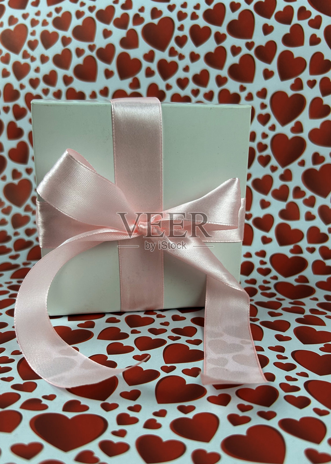 礼物有一个粉红色的蝴蝶结和心形的背景。情人节概念。情人节横幅照片摄影图片