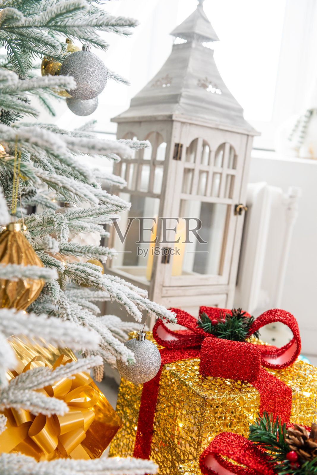 新年和圣诞节。一个经典的明亮舒适的房间，有壁炉，蜡烛，一棵白雪覆盖的圣诞树和大量的花环和灯。照片摄影图片