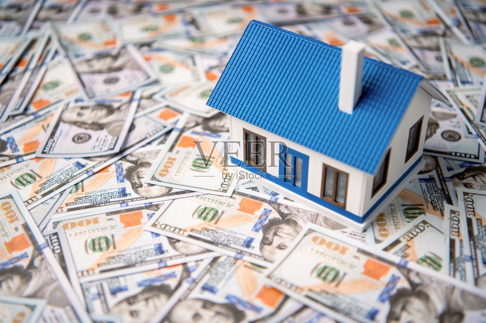 以美元钞票为背景的微型房子，房地产投资和储蓄的概念。照片摄影图片