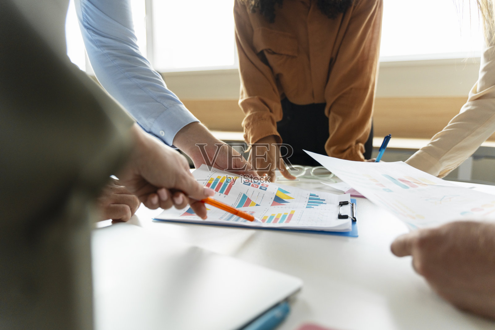 在现代办公室里，一群商人用图表一起工作，进行头脑风暴照片摄影图片