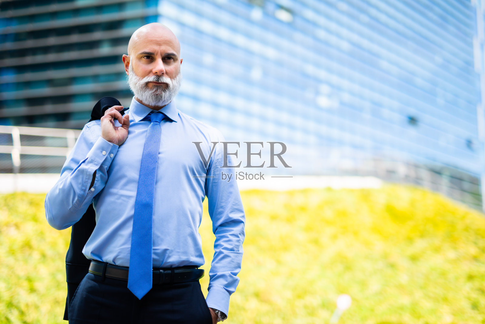 成熟的秃顶时尚的商人肖像与白胡子在户外拿着他的外套照片摄影图片