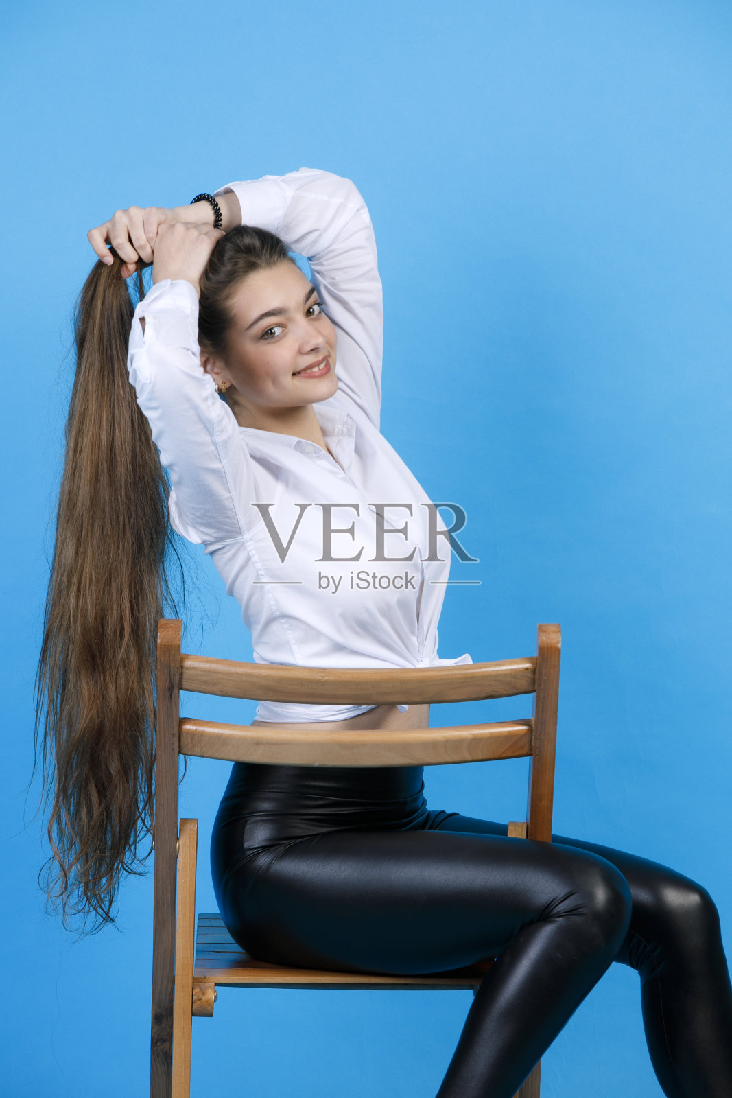 华丽的，微笑的女人很长的金发做美发，而在相机内摆姿势。照片摄影图片