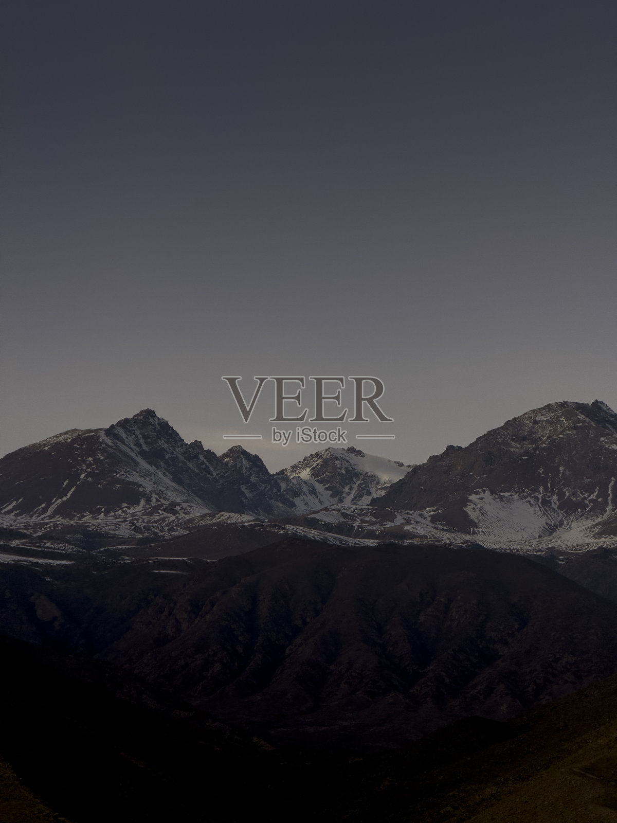 山脉的地平线上，白雪覆盖的山顶沐浴在温暖的色彩中照片摄影图片