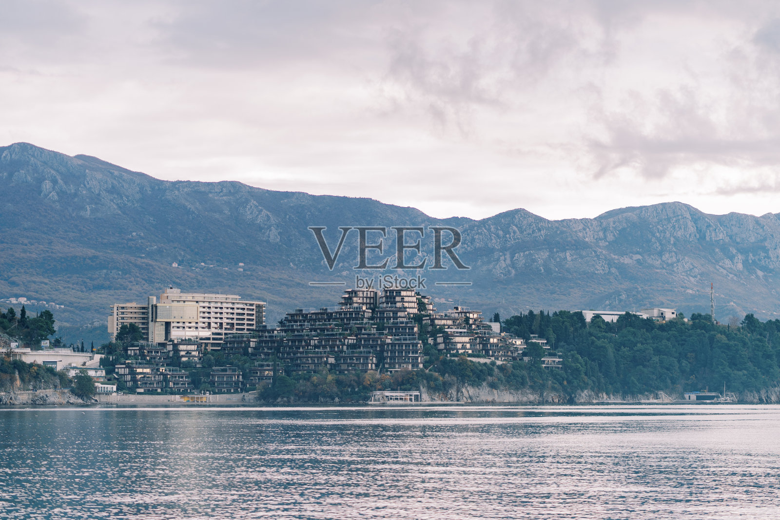 Dukley酒店的建筑坐落在海边的山脚下。Budva、黑山照片摄影图片