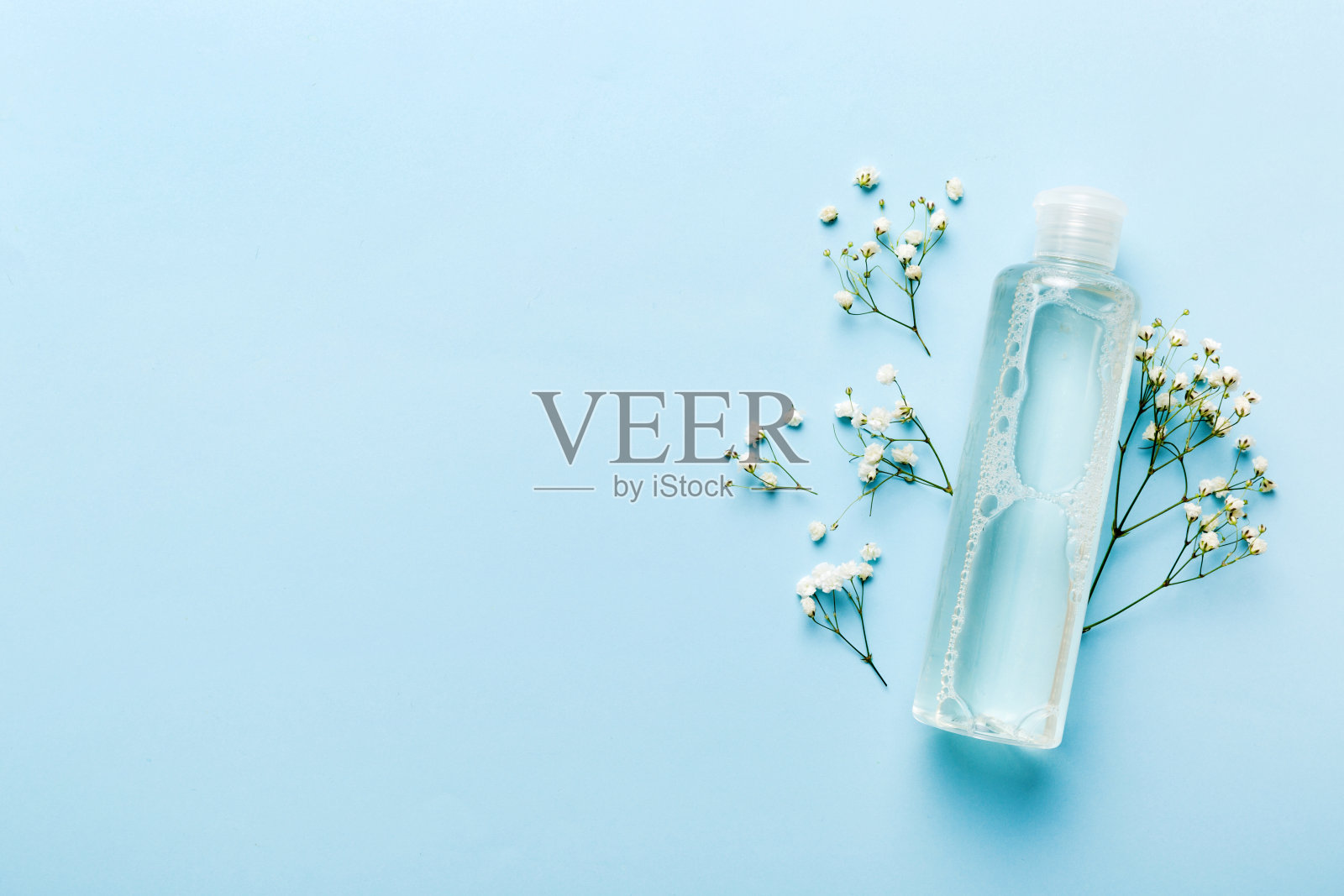 花式保健瓶的精华，胶束，滋补，爽肤水，乳液，水和乳霜与gypsophila分支。天然有机spa化妆品概念。模型，模板，俯视图照片摄影图片