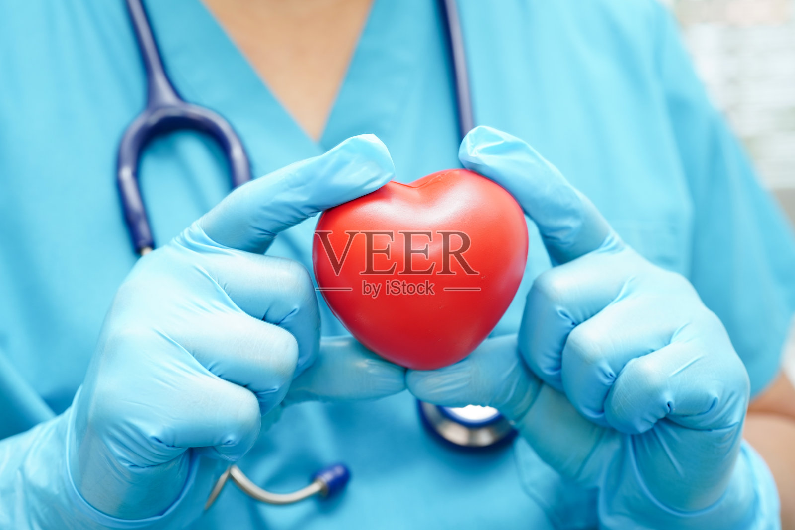 亚洲女医生在医院里为健康抱着红心。照片摄影图片