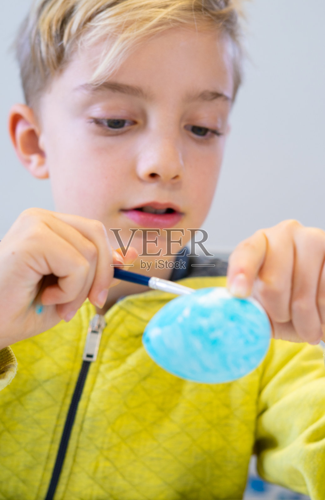 专心的孩子在装饰复活节彩蛋照片摄影图片