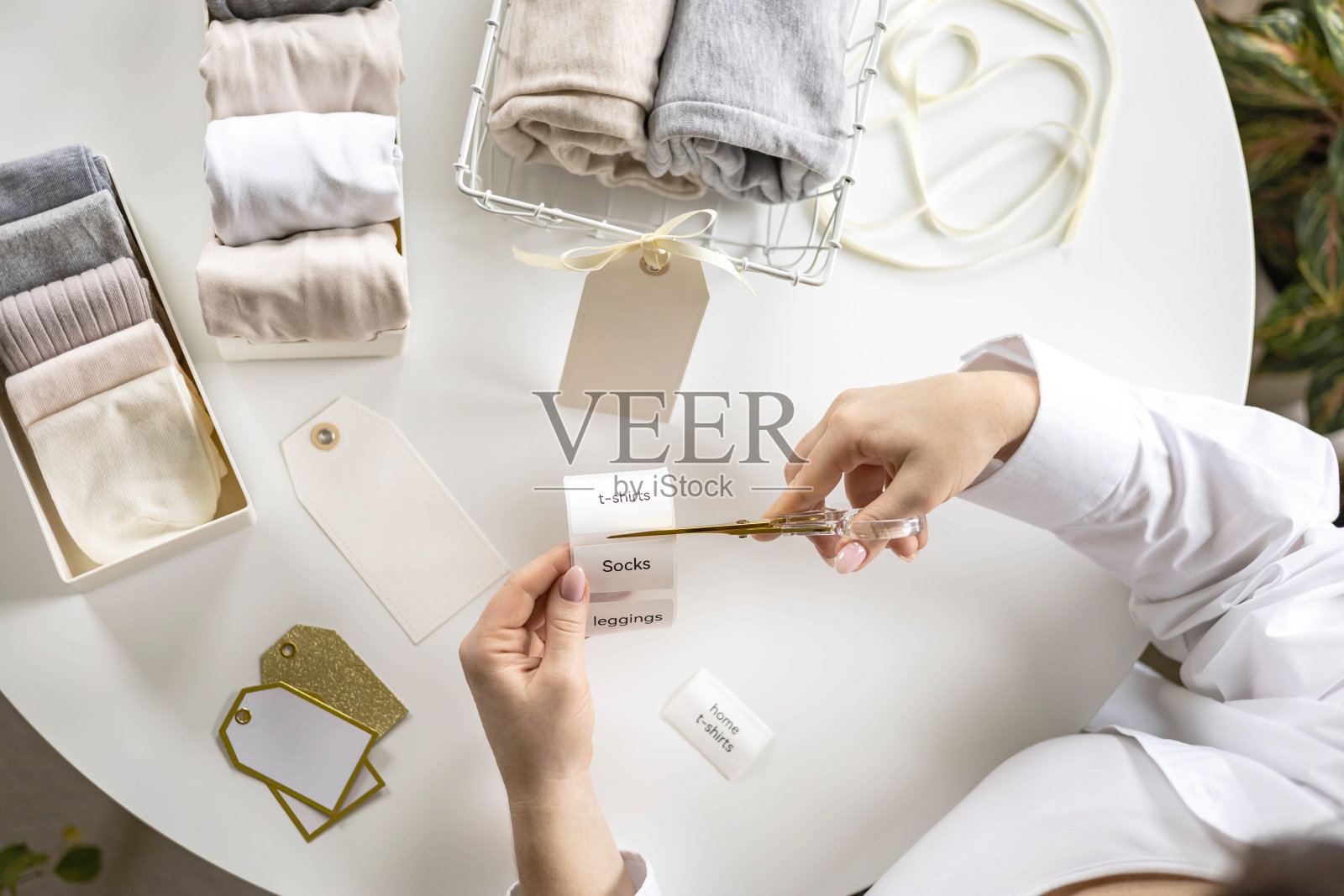 女人的手裁不干胶标签剪刀舒适储存整理亚麻纺织品在容器照片摄影图片