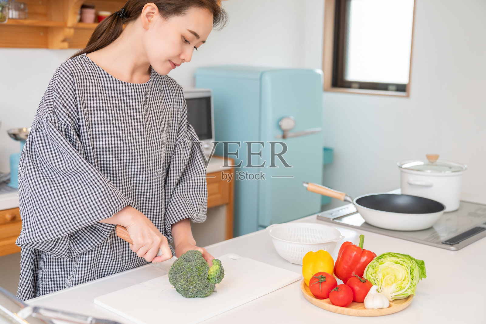 亚洲女人在厨房里煮西兰花照片摄影图片
