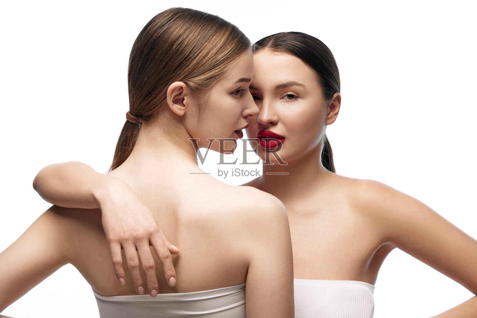 健康和健康。不同肤色的年轻漂亮女士们站在一起，在白色的背景下摆姿势。照片摄影图片