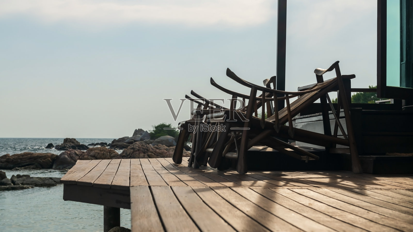 日落时海边露台上的木制扶手椅，罗勇高万巴生照片摄影图片