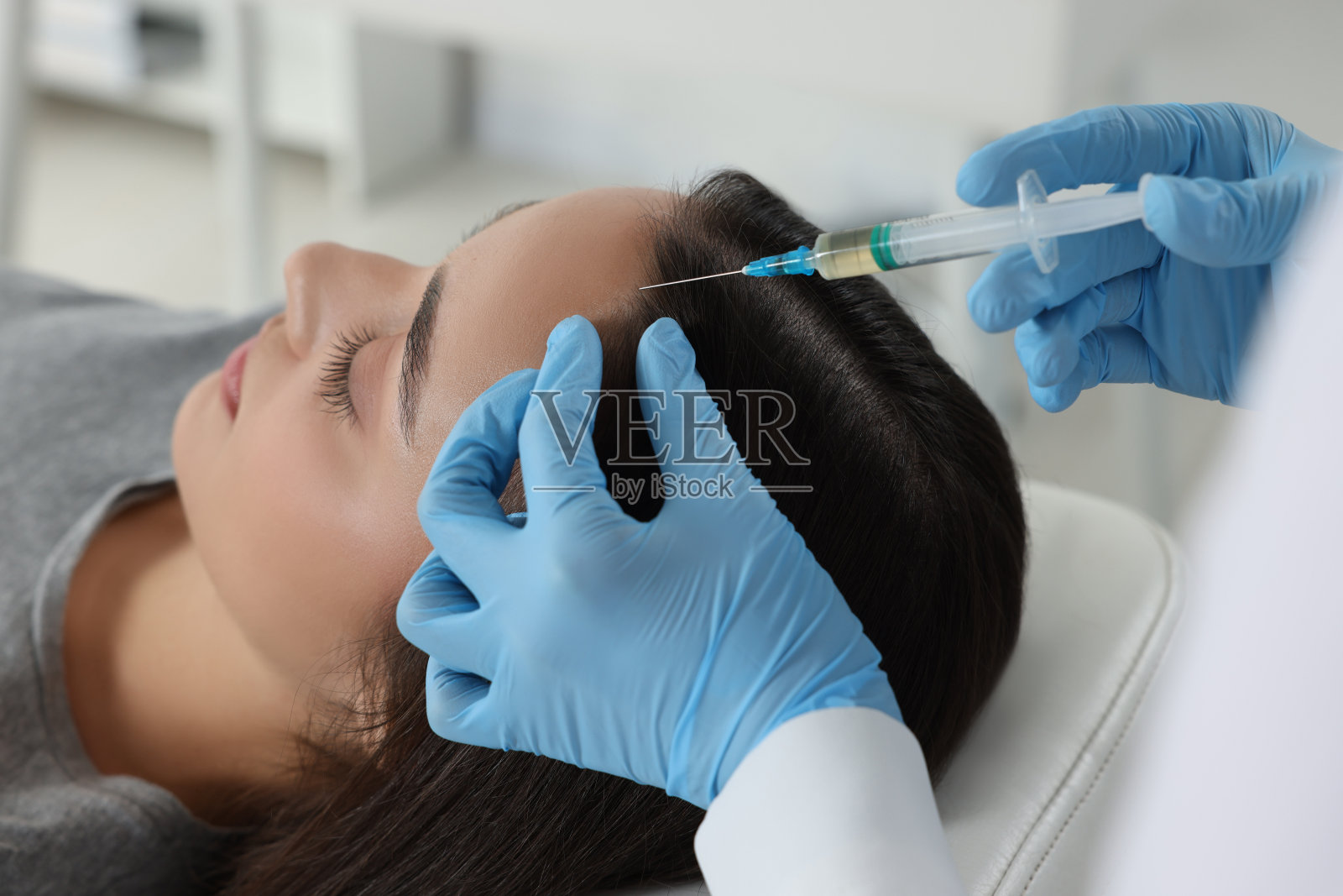 毛学家在诊所给病人注射，特写照片摄影图片