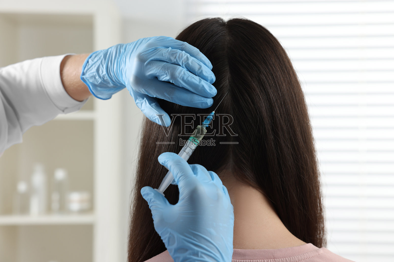 毛学家在诊所给病人注射，特写照片摄影图片