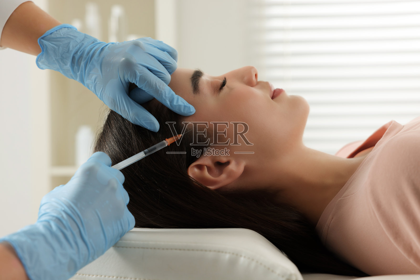 毛学家在诊所给病人注射，特写照片摄影图片