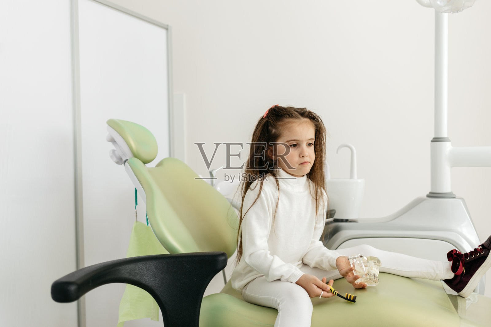 可爱的小女孩坐在牙科诊所的椅子上微笑照片摄影图片