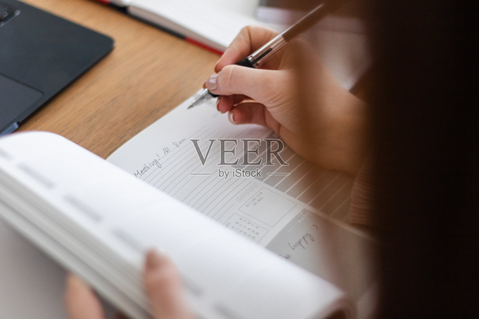 一个年轻女人在记事本上写东西的特写照片摄影图片