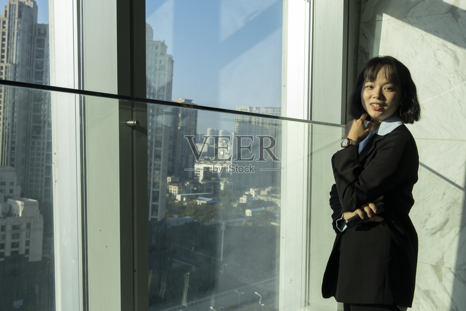 漂亮的女老板愉快地享受着透过办公室玻璃窗照射进来的阳光照片摄影图片