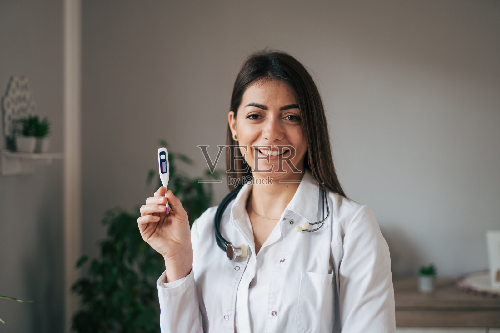 女医生拿着数字体温计照片摄影图片