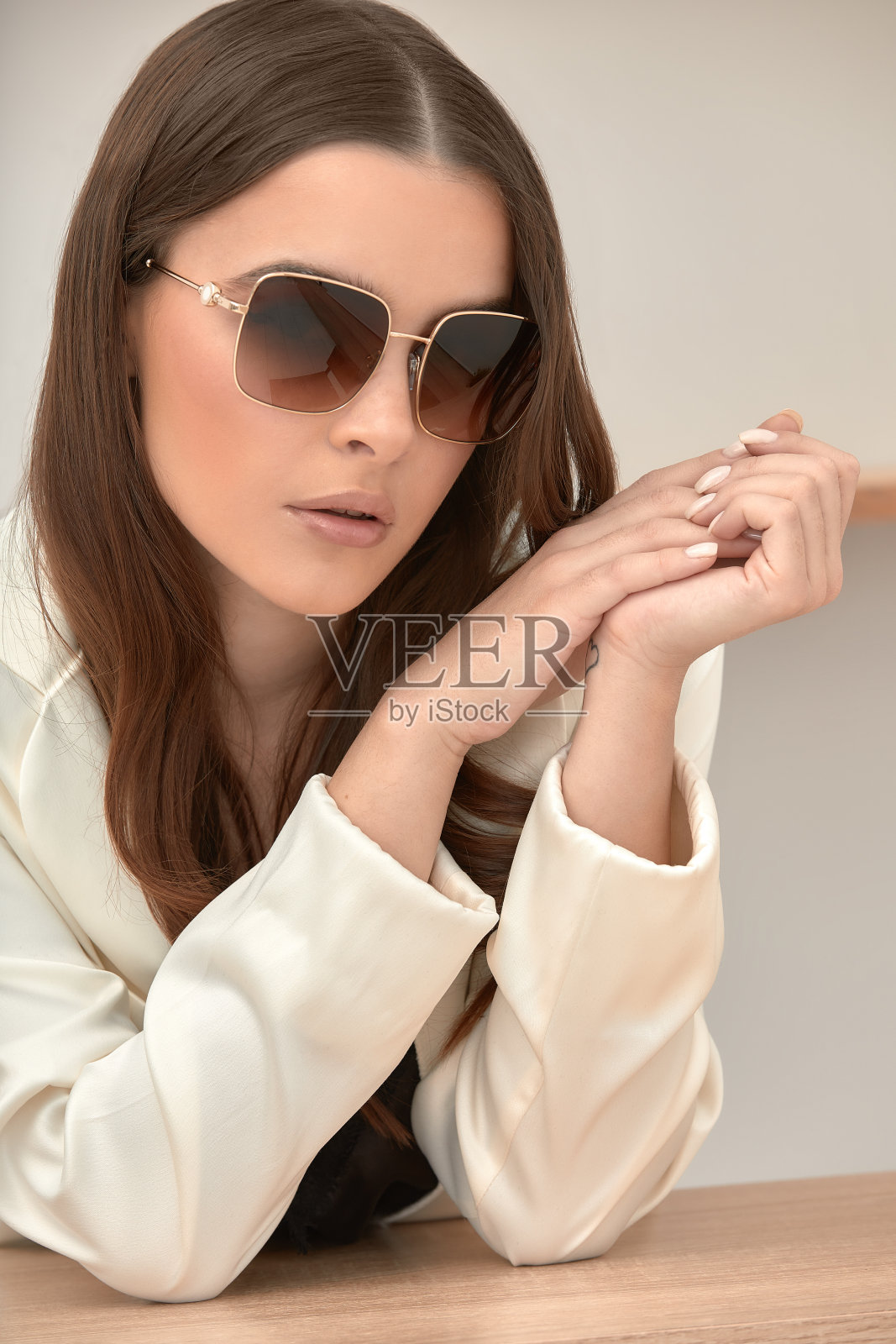 一个年轻的成功女性戴着眼镜，穿着轻薄的衣服。照片摄影图片