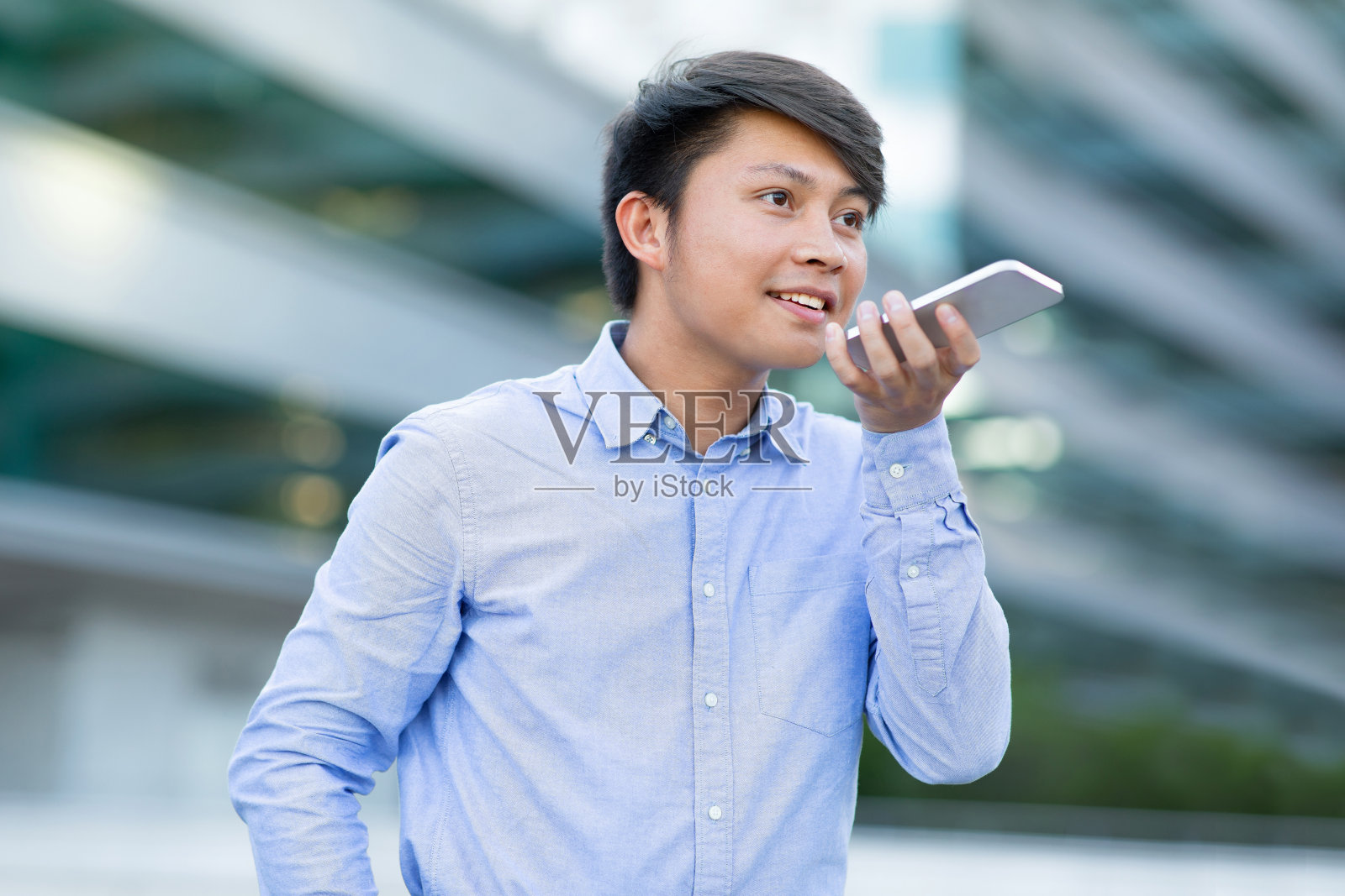 亚洲商务专业人士在户外通过扬声器电话应用程序交谈照片摄影图片