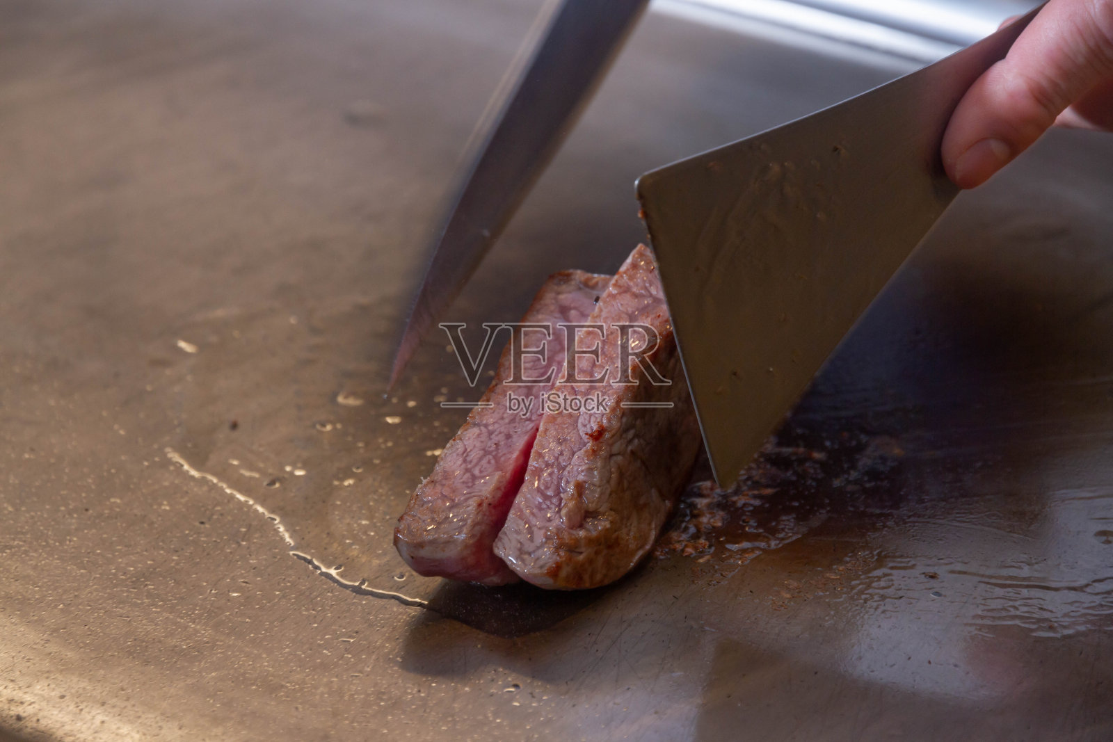 烹饪菲力牛排的场景。照片摄影图片