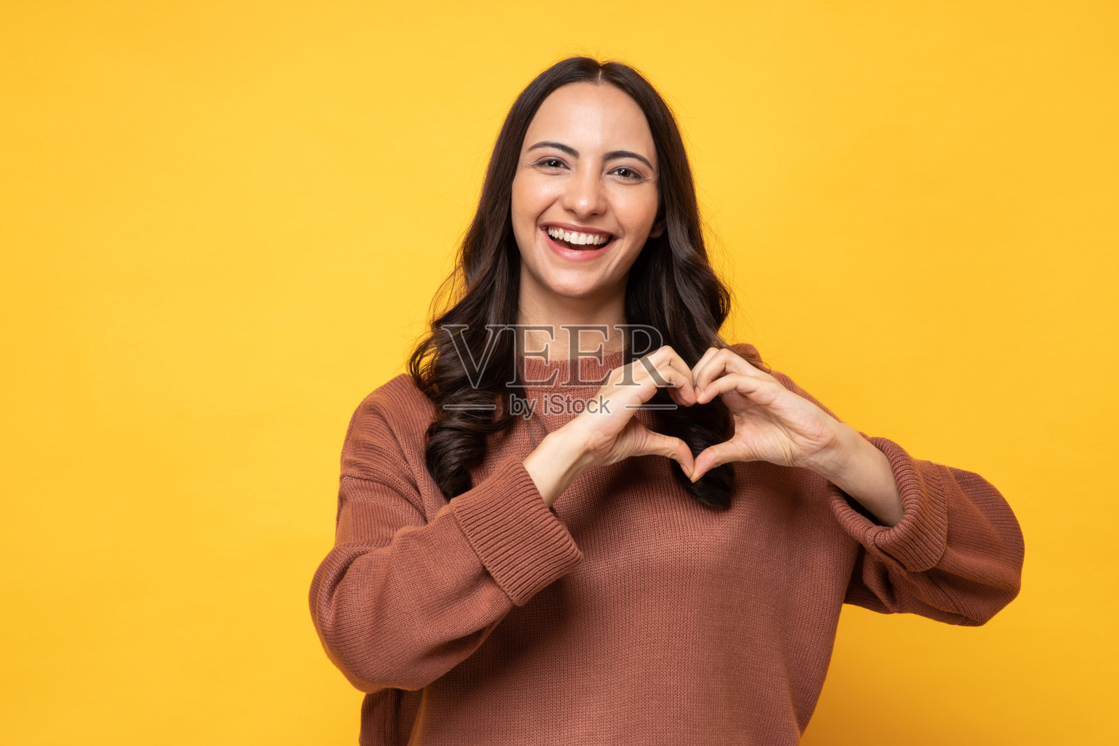 照片的年轻妇女在冬天穿站在黄色背景股票照片照片摄影图片