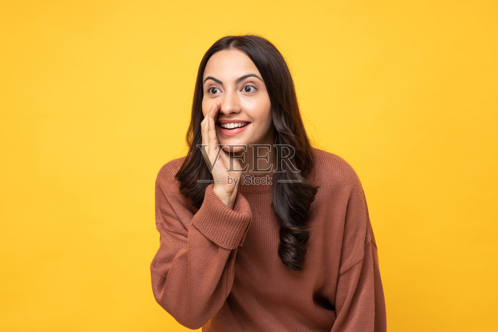 照片的年轻妇女在冬天穿站在黄色背景股票照片照片摄影图片