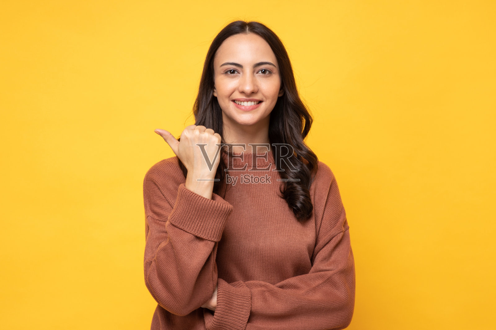 照片的年轻妇女在冬天穿站在黄色背景股票照片照片摄影图片