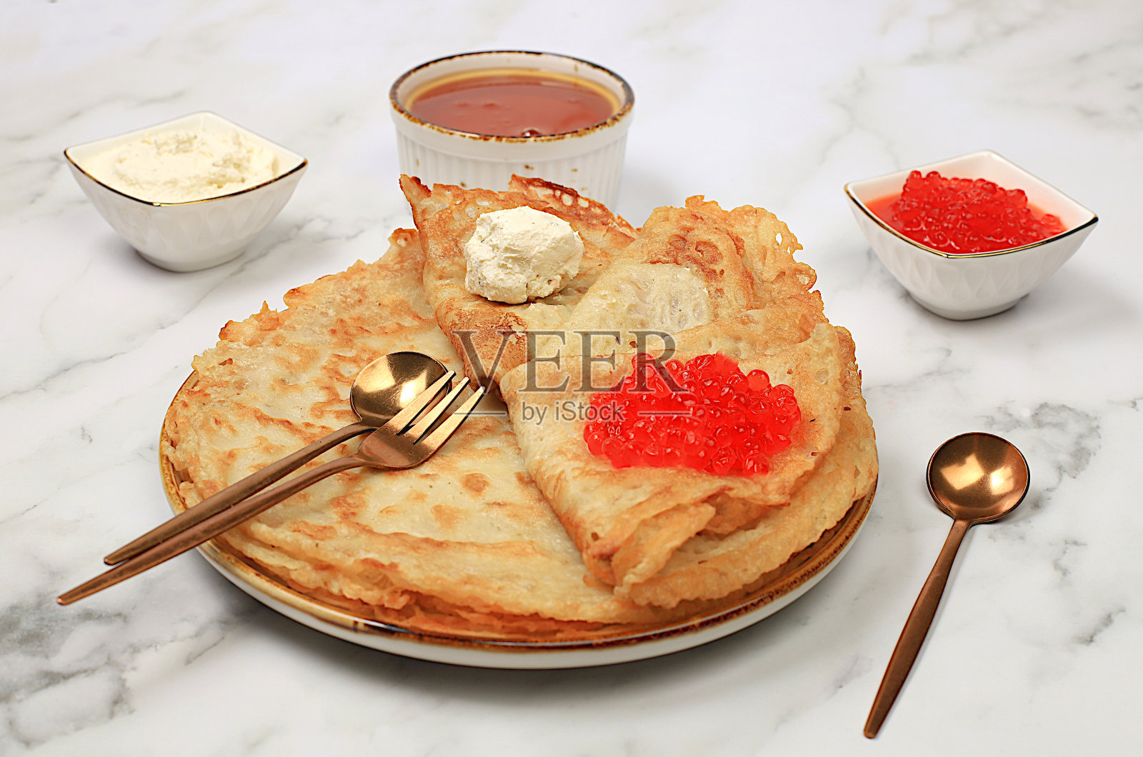 美味的俄罗斯煎饼配红鱼子酱，软奶酪凝乳和蜂蜜，在大理石桌子上。食材健康早餐，嘉年华概念，民族传统美食，照片摄影图片