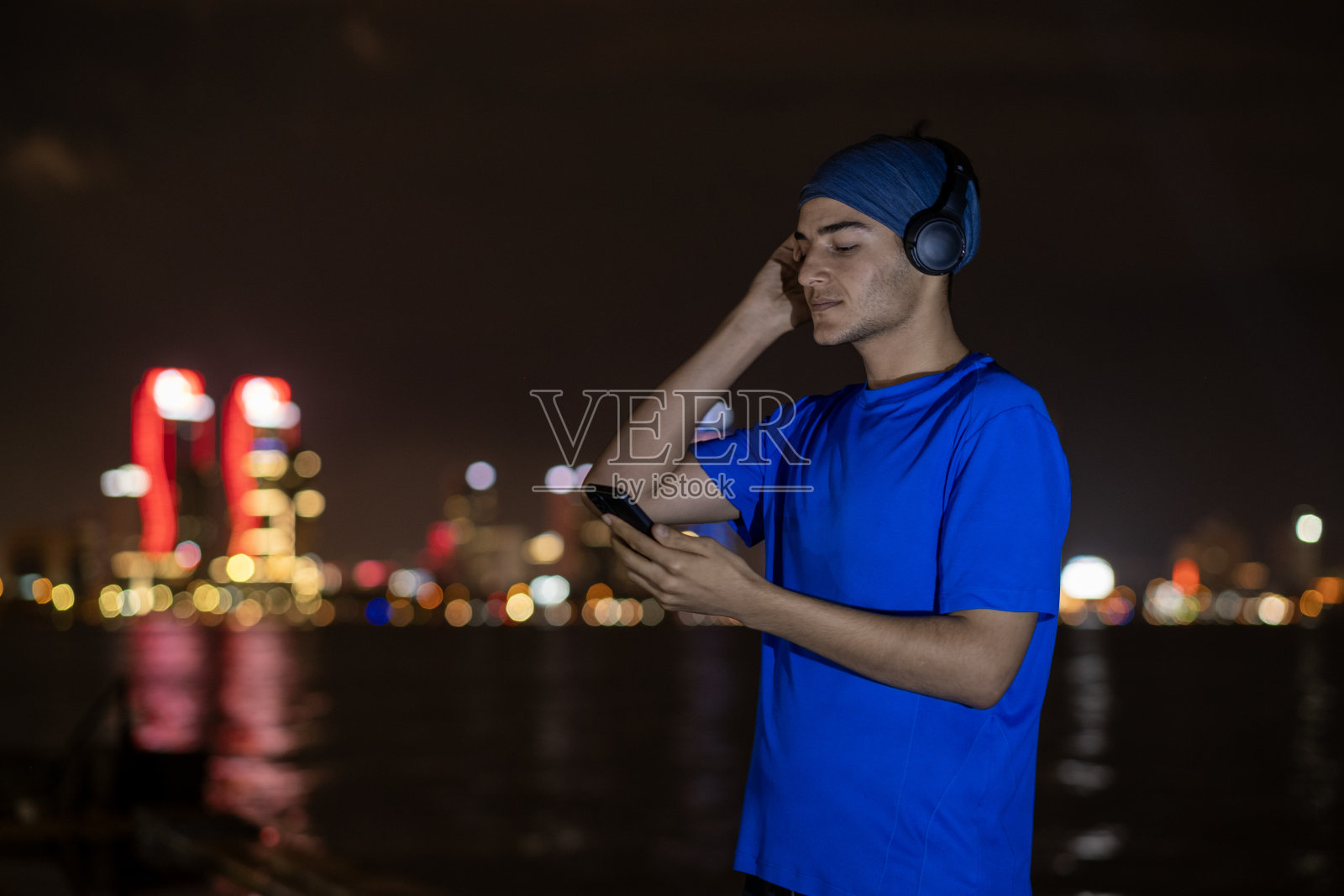 年轻人做运动，听音乐在夜晚的城市照片摄影图片