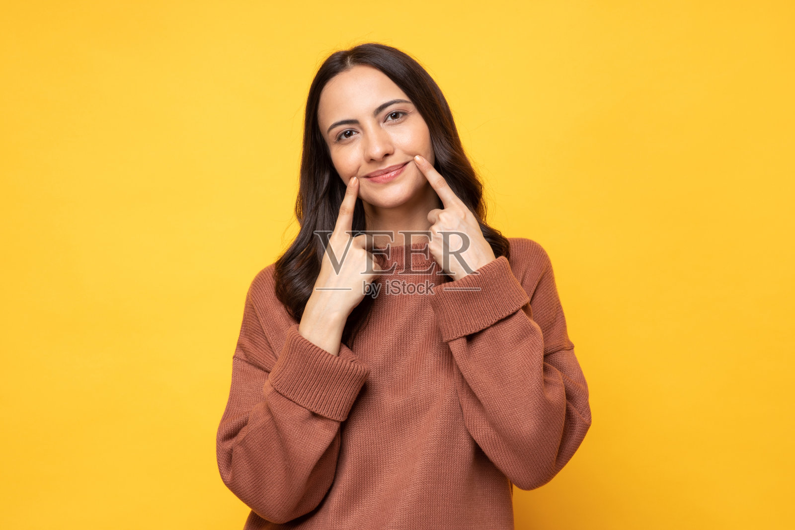 照片的年轻妇女在冬天穿站在黄色背景股票照片照片摄影图片