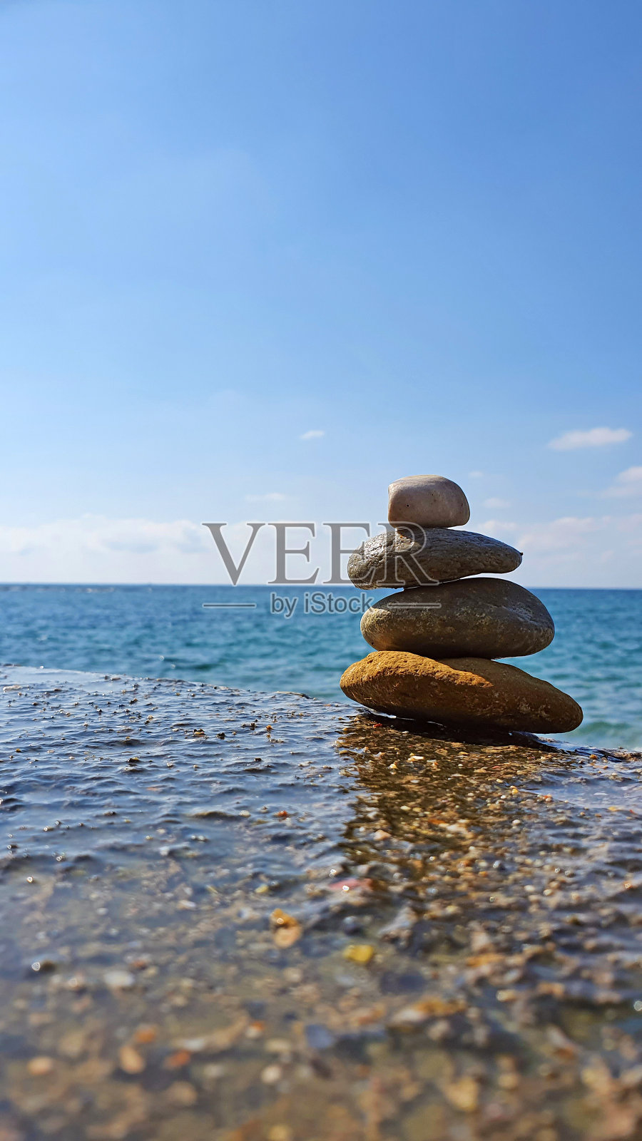 海滩上的石头金字塔。和谐和放松的概念。照片摄影图片