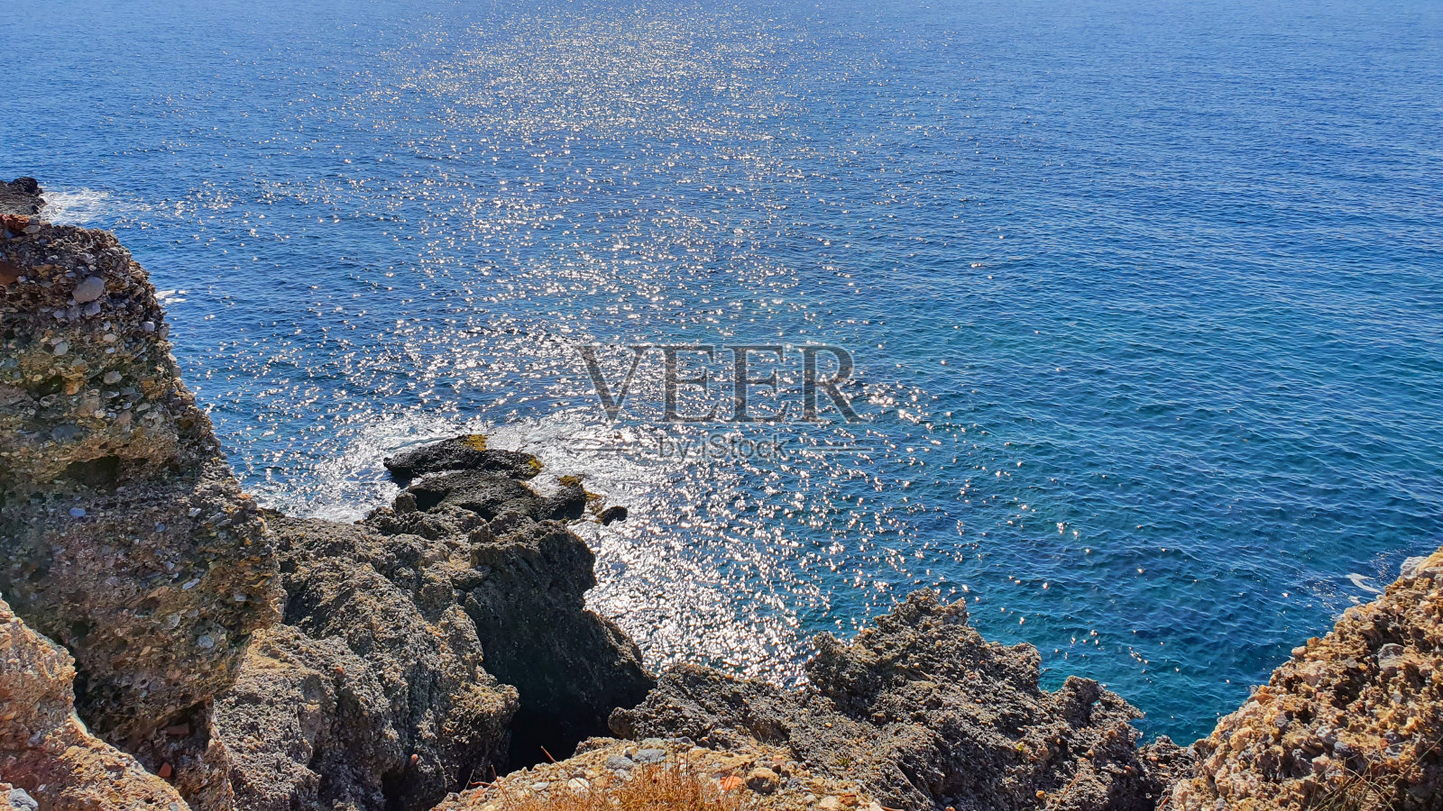 蔚蓝的天空和海边的岩石沙滩。照片摄影图片