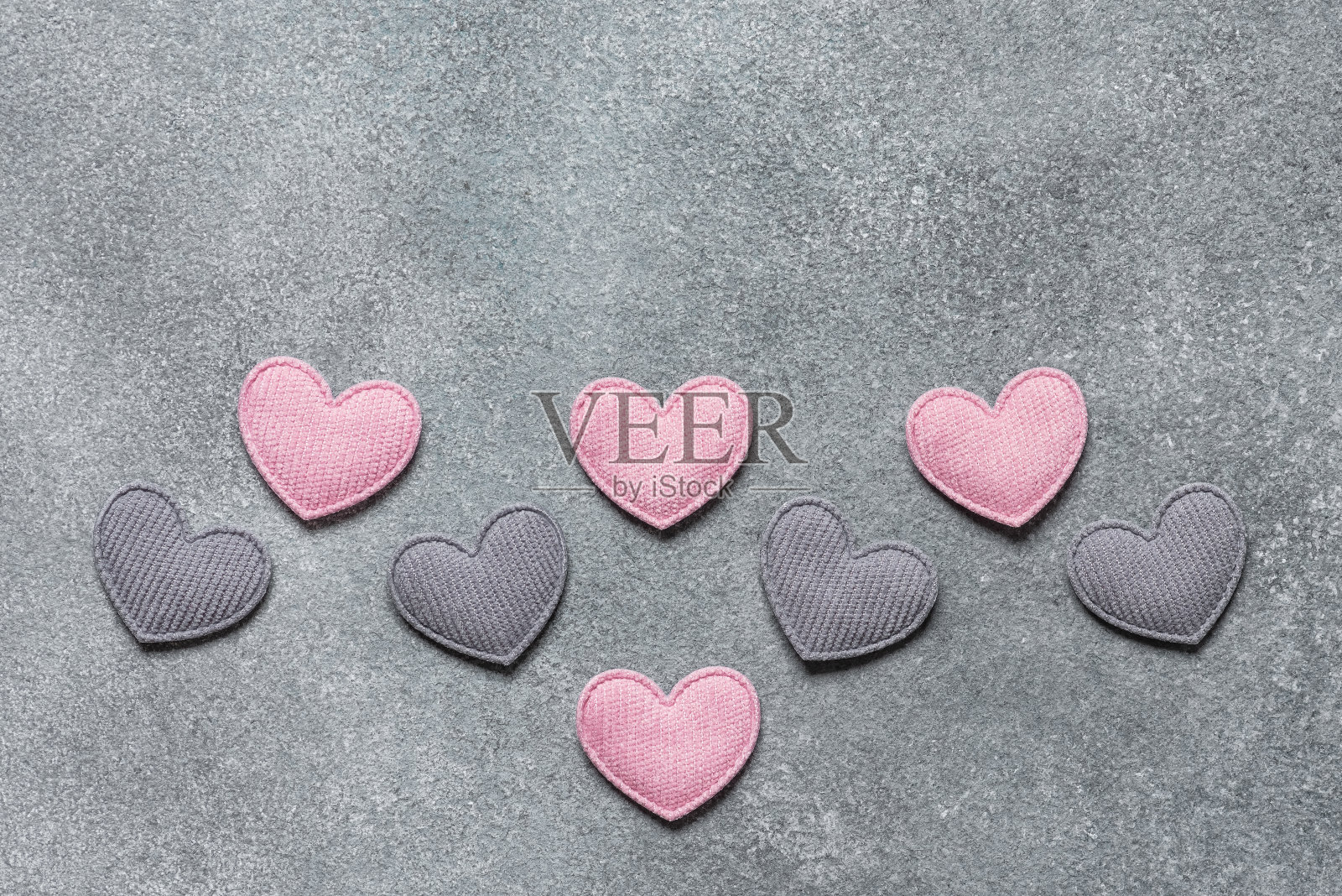粉红色和灰色的心在一个具体的背景边界。俯视图，平铺。情人节。照片摄影图片
