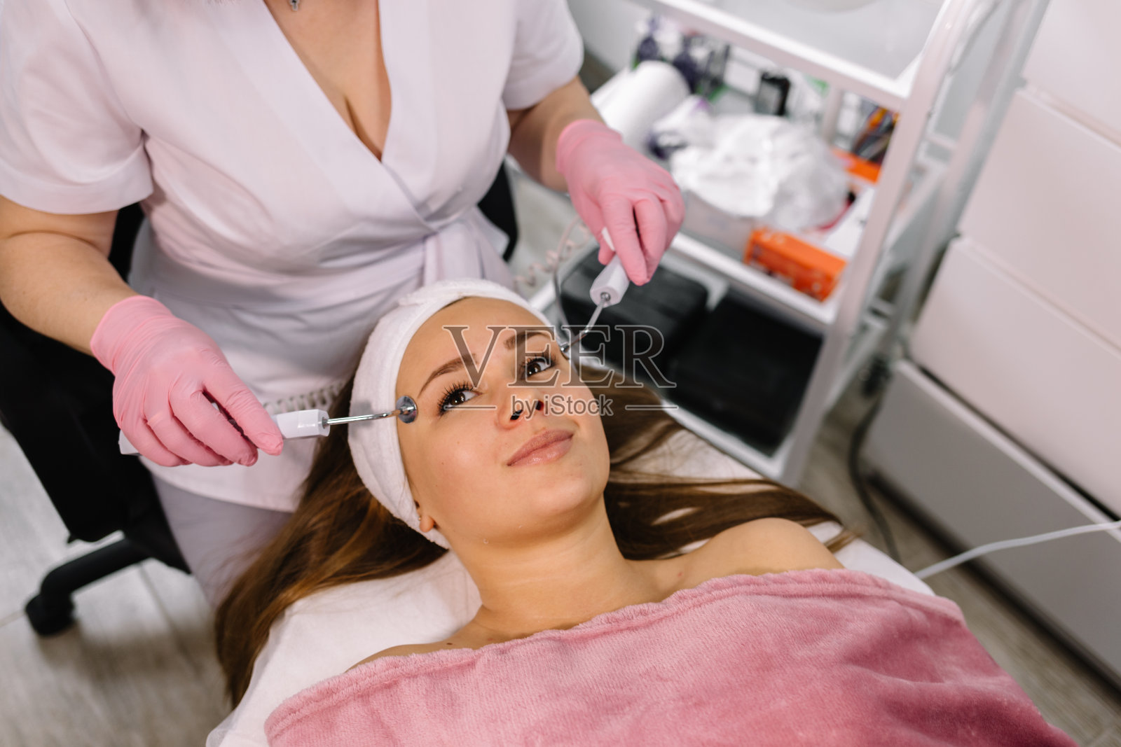 一个面带微笑的美丽女孩在一家美容诊所接受了脱皮手术。医疗保健、诊所、美容师。照片摄影图片