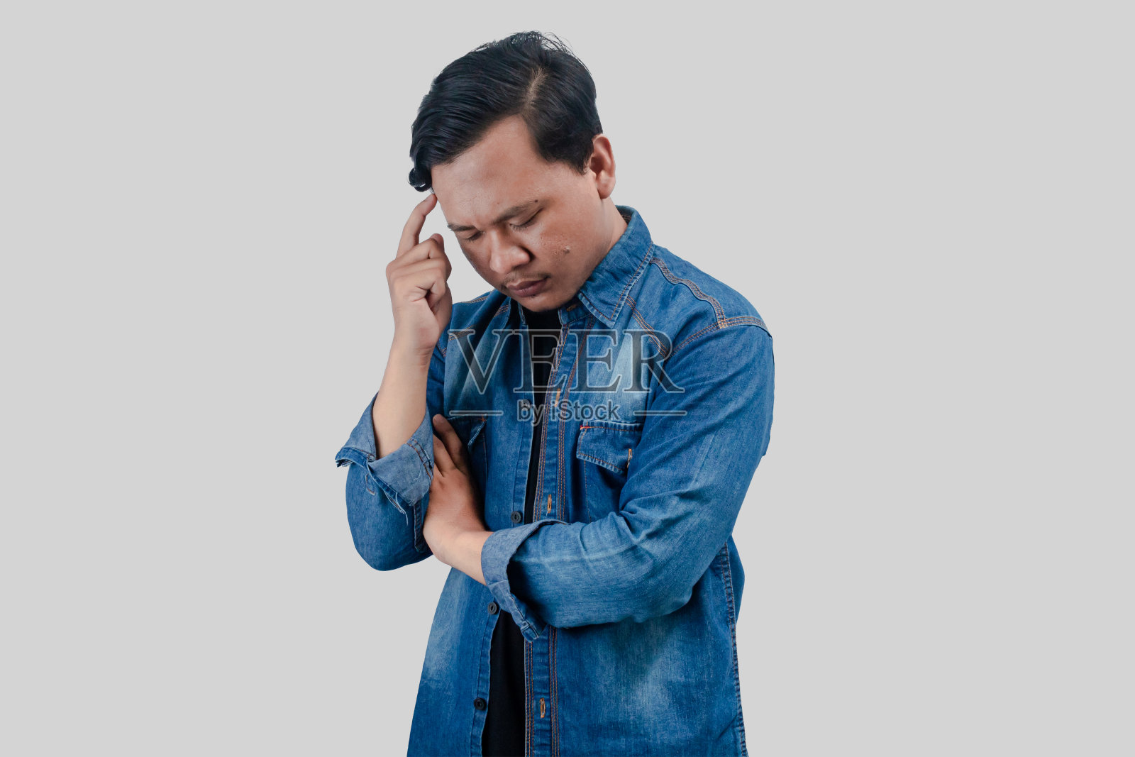 年轻的亚洲男子在思考问题时脸上带着沉思的表情照片摄影图片