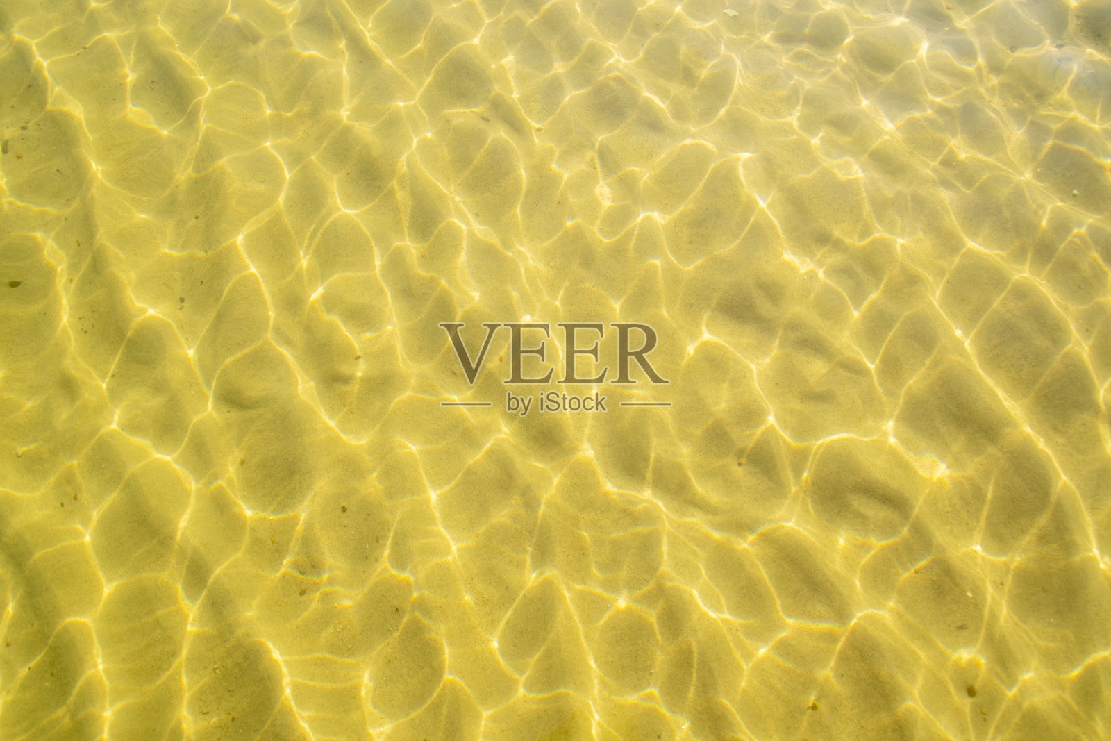 金色沙滩上的海水。阳光照在沙质海底。海滩上清澈的海水。照片摄影图片