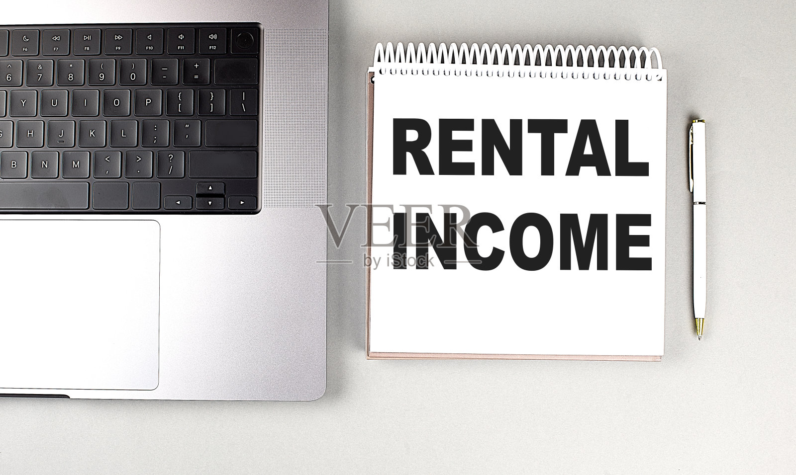 租金收入文本的笔记本电脑与笔记本电脑和笔照片摄影图片