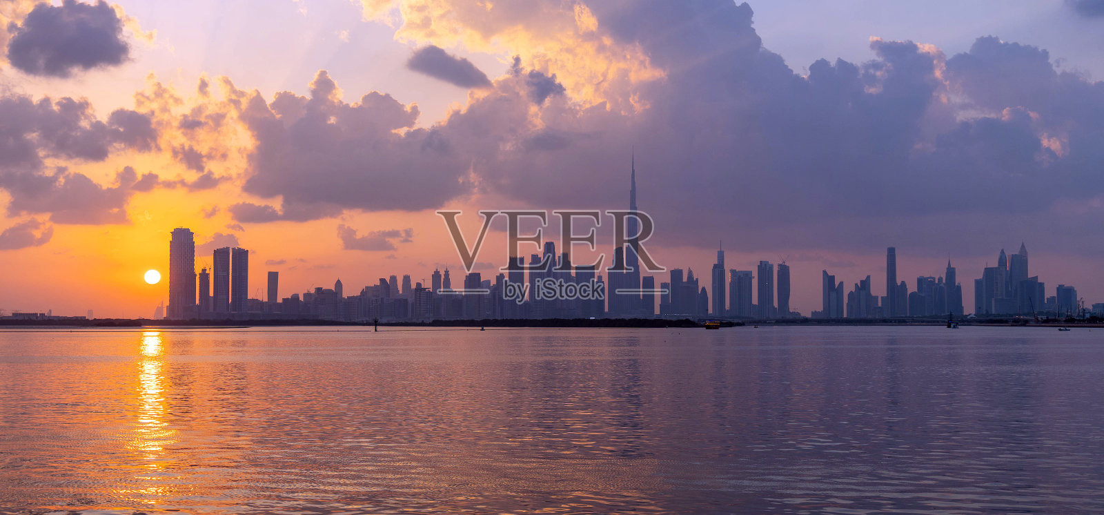 从迪拜河运河看到的迪拜市中心全景日落照片摄影图片