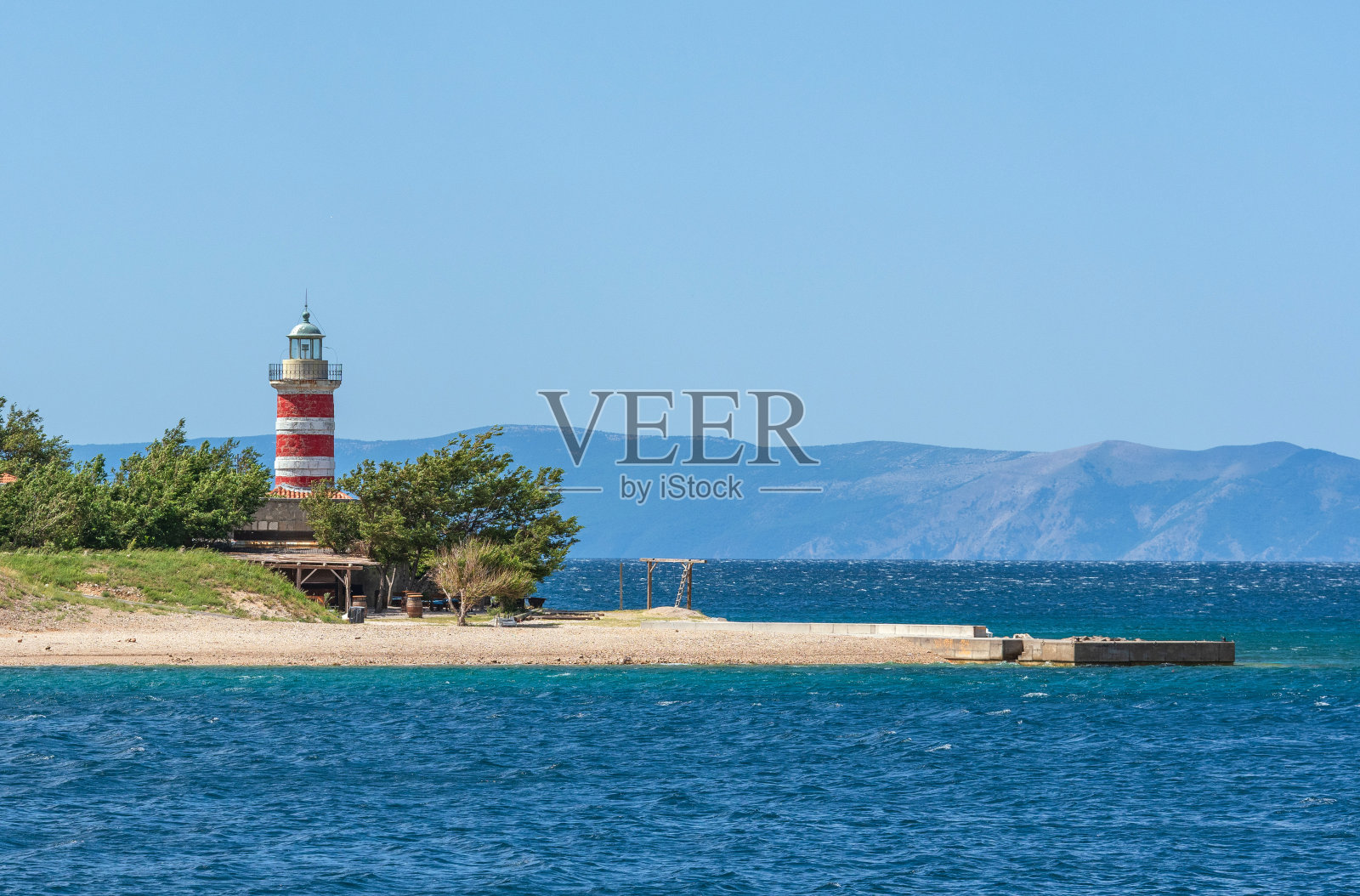 美丽的景色田园诗般的灯塔在小海角与沙滩在一个阳光明媚的夏日照片摄影图片